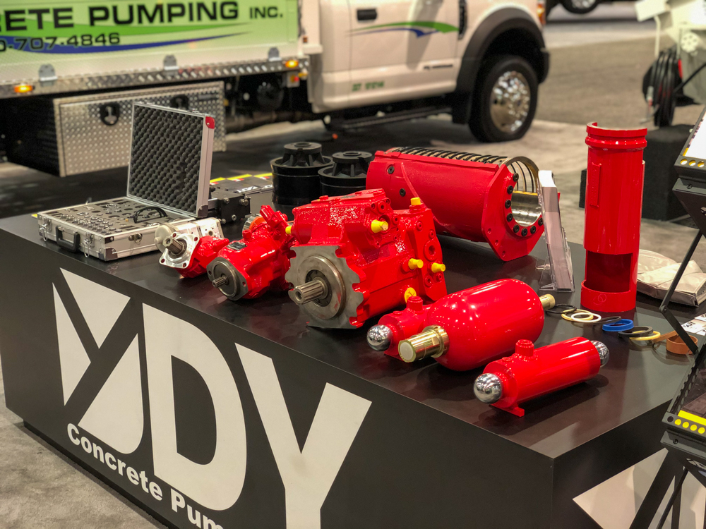 DY Concrete Pumps pump parts on a table inside of the WOC event