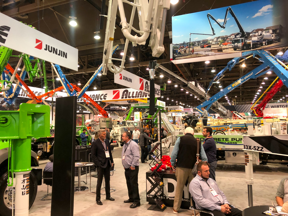 DY Concrete Pumps employees discussing concrete pumps with visitors at the WOC event