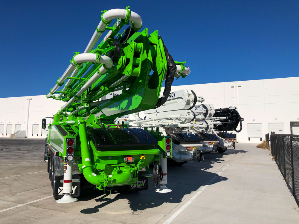 view from behind of 4 different concrete boom pumps manufactured by DY Concrete Pumps